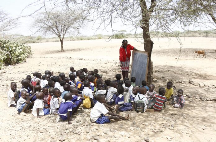 teacher and pupils under a tree